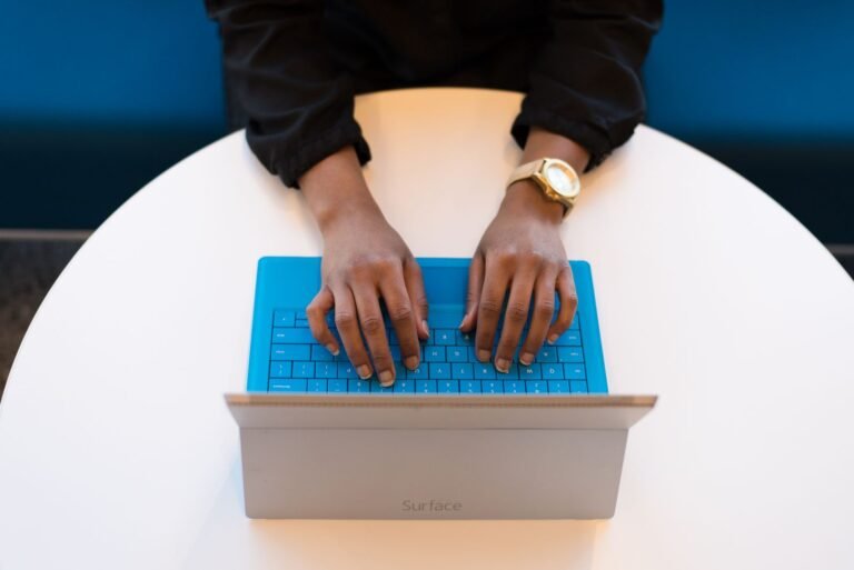 Person typing on a laptop filling out a contact form